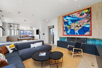 a living room with a blue couch and a colorful painting on the wall at Inspire West Town, CHICAGO, 60642